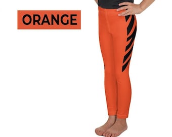May include: Two young girls wearing black t-shirts and orange leggings with black diagonal stripes. The word "ORANGE" is displayed in a rectangular orange box with black text.