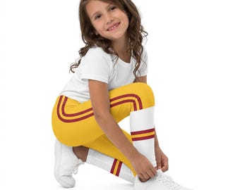 May include: Yellow leggings featuring two horizontal maroon stripes along the upper thigh and two maroon stripes above a white band at the lower calf, paired with a plain white short-sleeved t-shirt and white sneakers.