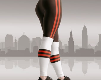 May include: A woman wearing brown leggings with orange stripes and white socks with orange stripes. She is wearing black running shoes with orange accents. The background is a blurry cityscape.