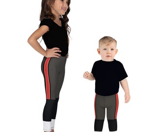 May include: Two children wearing black shirts and gray leggings with red and yellow stripes. The leggings have a black and white stripe at the bottom. The word "BROWN" is written in red letters at the top of the image.