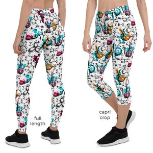Puede incluir: Leggings y pantalones capri blancos con un patrón colorido de instrumentos musicales, equipos científicos y formas abstractas. El diseño incluye salpicaduras de color turquesa, rosa y naranja, con detalles en negro y texto manuscrito.