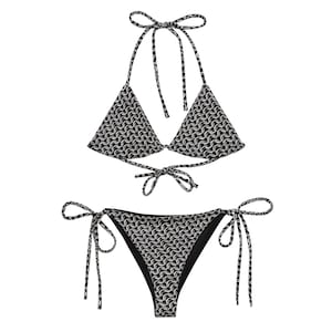 May include: A two-piece bikini set with a black and white chainmail pattern. The top is a halter style with triangle cups and ties at the neck and back. The bottoms are a classic cut with side ties.