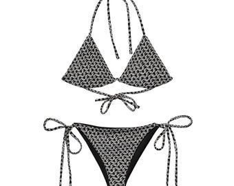 May include: A two-piece bikini set with a black and white chainmail pattern. The top is a halter style with triangle cups and ties at the neck and back. The bottoms are a classic cut with side ties.