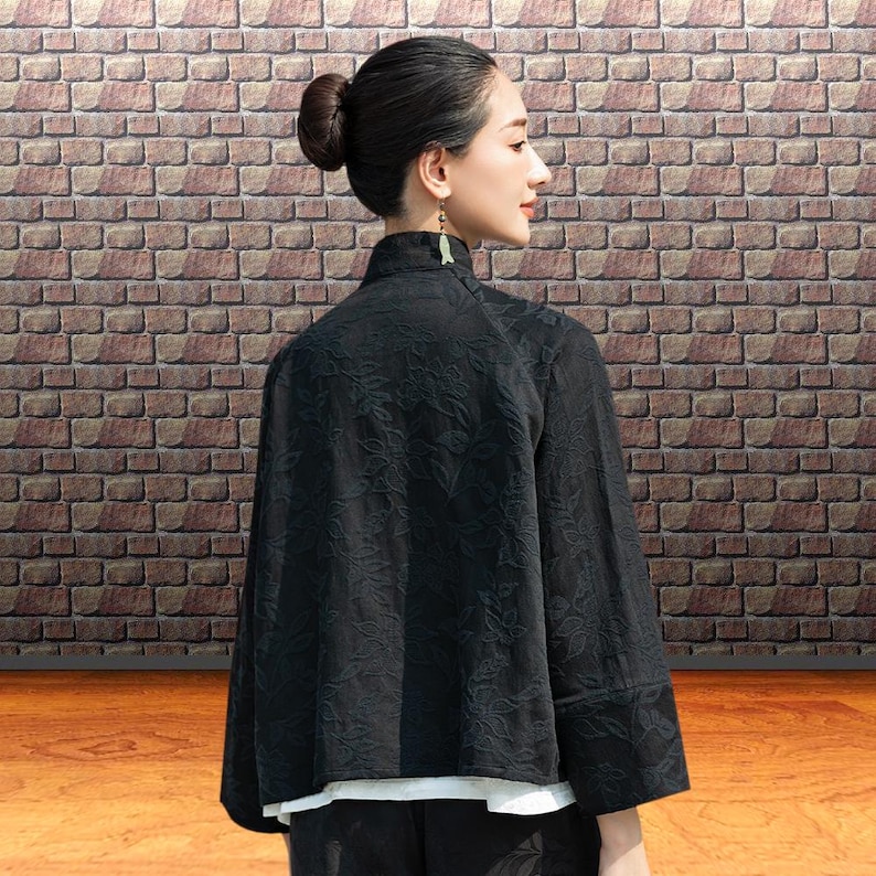 This black floral jacquard linen jacket offers a structured yet breathable layer for the autumn transition, blending traditional frog button details with modern fit. This piece uses the natural weight of flax linen. The "Deep Carbon Black" isn't a flat dye; the tonal jacquard weave adds a subtle dimension that becomes visible as you move. Functions as a soft blazer for the office or a meditative outer layer for weekend outings.