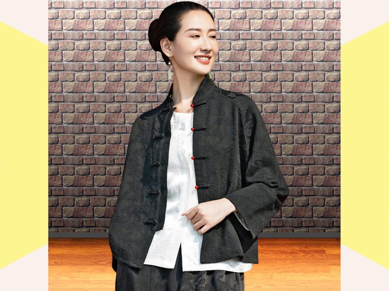 This black floral jacquard linen jacket offers a structured yet breathable layer for the autumn transition, blending traditional frog button details with modern fit. This piece uses the natural weight of flax linen. The "Deep Carbon Black" isn't a flat dye; the tonal jacquard weave adds a subtle dimension that becomes visible as you move. Functions as a soft blazer for the office or a meditative outer layer for weekend outings.