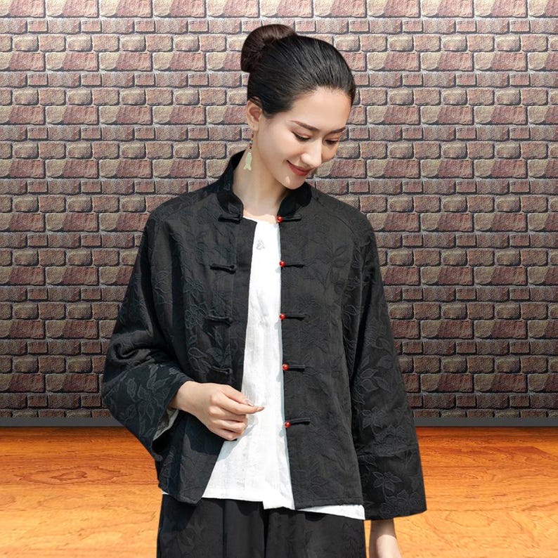 This black floral jacquard linen jacket offers a structured yet breathable layer for the autumn transition, blending traditional frog button details with modern fit. This piece uses the natural weight of flax linen. The "Deep Carbon Black" isn't a flat dye; the tonal jacquard weave adds a subtle dimension that becomes visible as you move. Functions as a soft blazer for the office or a meditative outer layer for weekend outings.