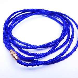 May include: A blue beaded waist chain with a gold clasp. The chain is made of small, round beads and is approximately 40 inches long.