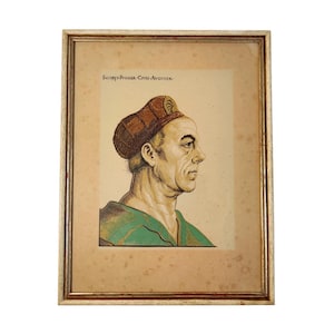 Op de afbeelding: Geraamde portret van een man in profiel, met een bruine hoed en een groen kledingstuk. Het kunstwerk zit in een goudkleurige lijst. De tekst bovenaan luidt "Iacopo Fugger, Civis Augustae."
