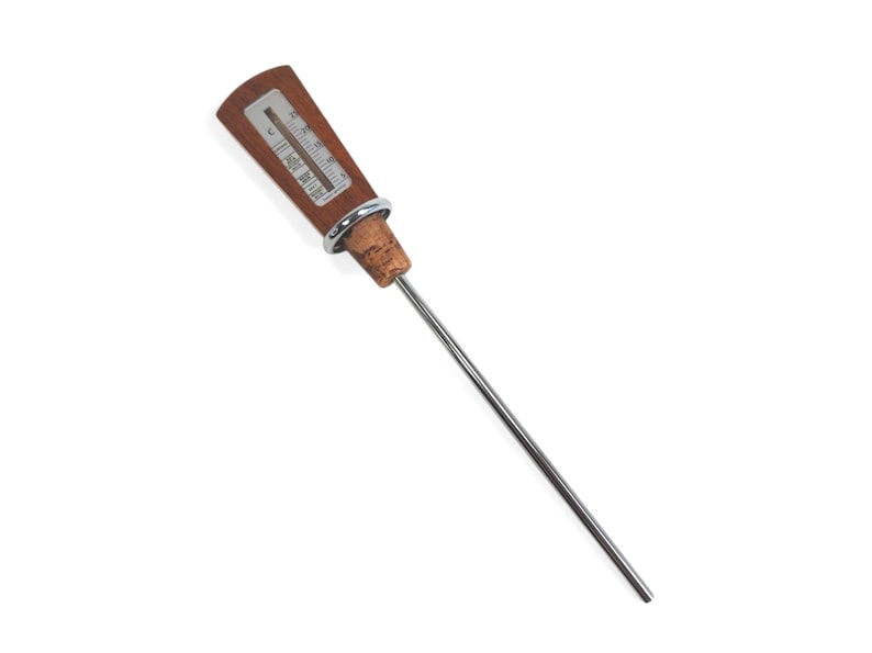 May include: A kitchen thermometer with a long, thin stainless steel probe, a cork stopper base, a silver-colored metal ring, and a rectangular wooden handle featuring a vertical temperature scale marked in degrees Celsius and Fahrenheit.