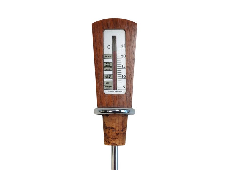 May include: A wine thermometer with a wooden handle featuring a vertical scale in Celsius from 5 to 25 degrees. The display includes labels for Cognac, Rotwein, Dessertwein, Weisswein, Sekt, and Branntwein. It has a cork stopper and a metal stem.