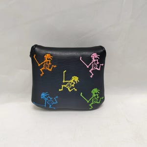 May include: Black leather golf club head cover with colorful embroidered figures.