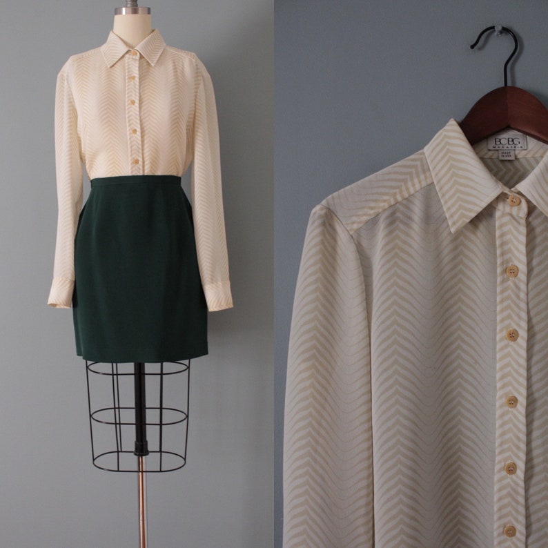 May include: A white long-sleeved blouse with a chevron pattern and button closure. The blouse is made of a lightweight fabric and has a relaxed fit. The brand label reads "BCBG Max Azria".