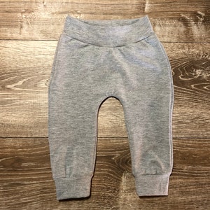 May include: Gray sweatpants with a wide elastic waistband and cuffed legs.