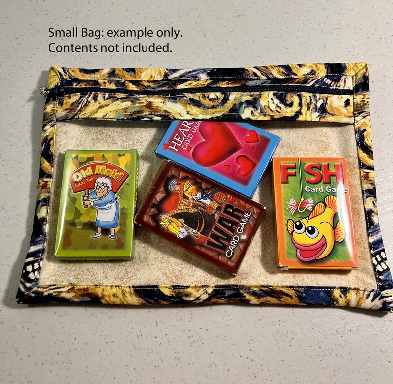 Puede incluir: Una peque&ntilde;a bolsa con cremallera con un estampado abstracto colorido. La bolsa est&aacute; abierta y contiene cinco juegos de cartas: Old Maid, Hearts, War, Fish y otro juego de cartas con un dise&ntilde;o rojo y azul. La bolsa est&aacute; hecha de tela y tiene una ventana de pl&aacute;stico transparente.