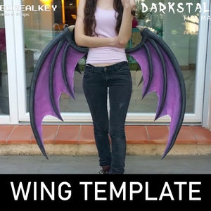May include: A pair of purple and black wings with a textured surface. The wings are held by a person in front of a window. The text "WING TEMPLATE" is at the bottom of the image.
