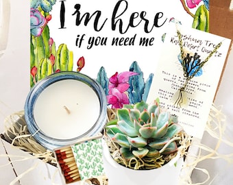 May include: A gift box filled with a white candle, a small potted succulent plant, a box of matches, and a card with the text "I'm here if you need me". The card also includes a small piece of raw desert quartz with a gold chain.