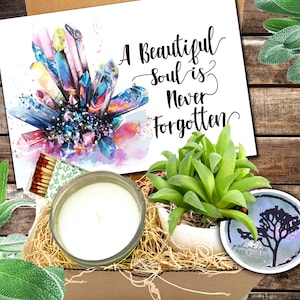 May include: A gift box filled with a candle, a small succulent plant, matches, and a card with the text "A Beautiful Soul is Never Forgotten".