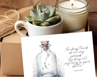 May include: A small white succulent plant in a white teacup, a lit candle in a glass jar, and a card with a watercolor illustration of a bottle with water droplets and the text "You keep track of all my sorrows. You keep all my tears in your bottle. Psalm 56:8."