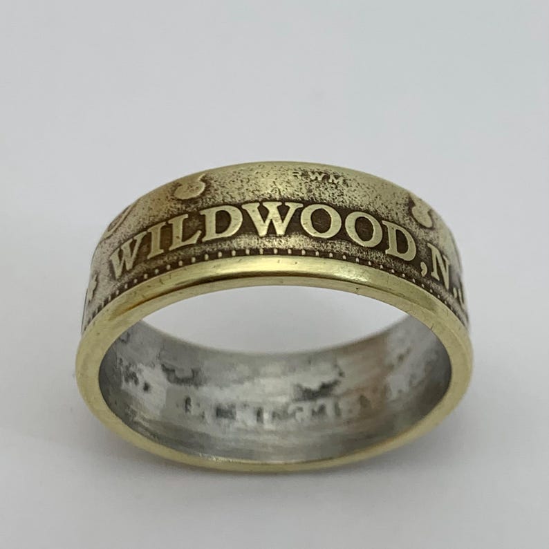 May include: A gold-toned ring with the words "WILDWOOD, NJ" engraved on the band.