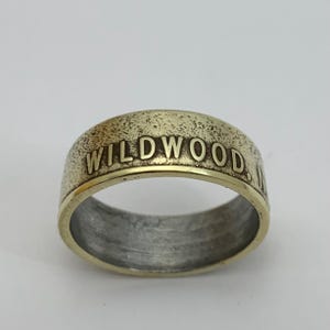 May include: A gold-colored ring with the words "WILDWOOD, NJ" engraved on the band.