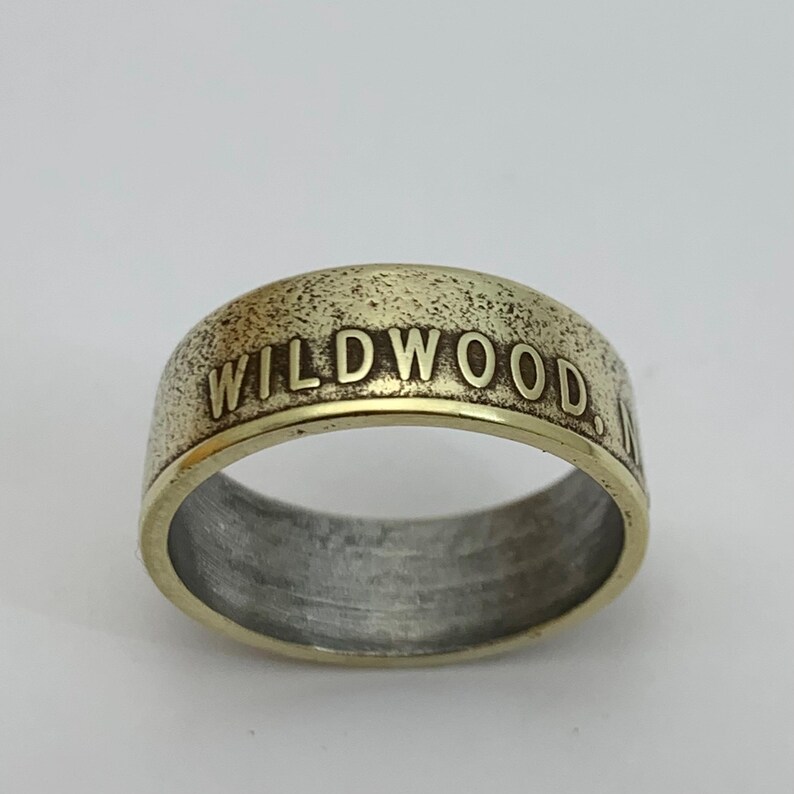 May include: A gold-colored ring with the words "WILDWOOD, NJ" engraved on the band.