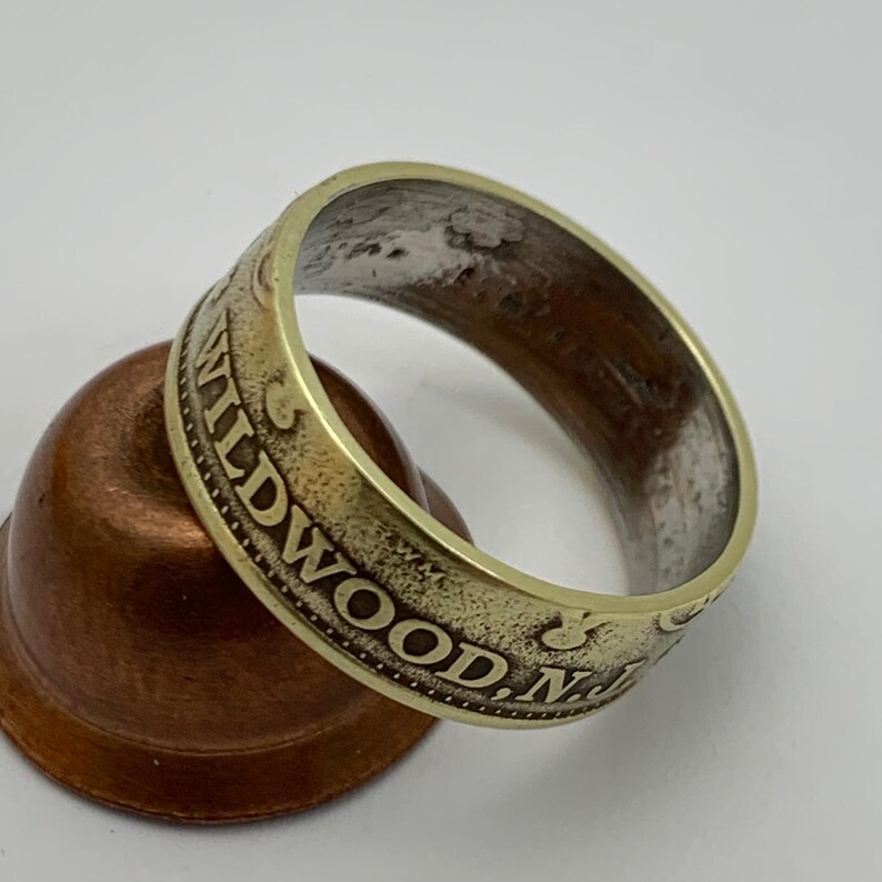 May include: A gold-colored ring made from a coin with the inscription "WILDWOOD, N.J." on the side.