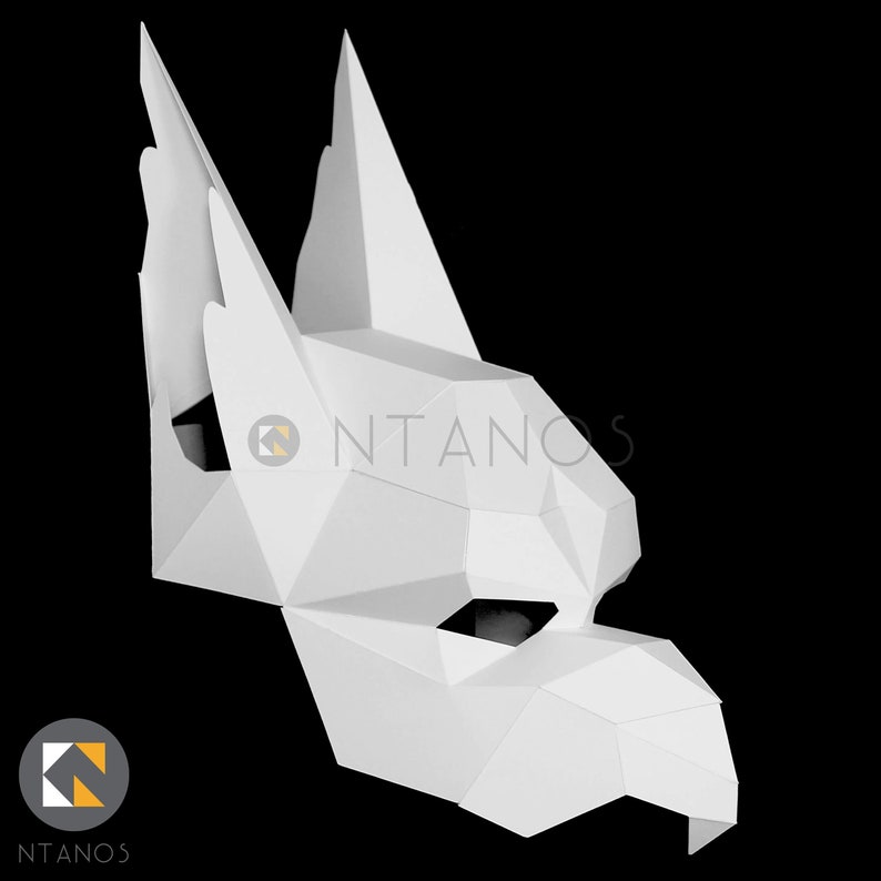 K&ouml;nnte beinhalten: Wei&szlig;e Papiermaske eines Wolfskopfes mit spitzen Ohren und einer langen Schnauze.