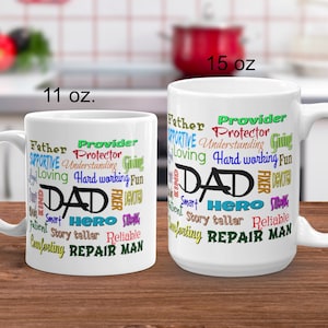 May include: White ceramic coffee mug with a word cloud design featuring the word "DAD" in black and other words in various colors, including "Father", "Provider", "Hero", "Repair Man", and "Story Teller". The mug is available in two sizes: 11 oz and 15 oz.