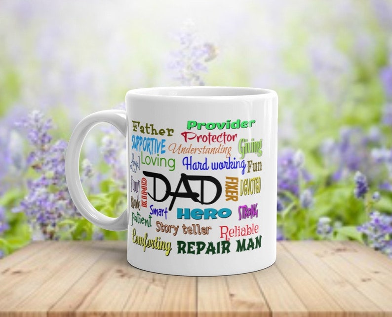May include: White ceramic coffee mug with a colorful word cloud design that reads "Provider, Father, Protector, Supportive, Understanding, Giving, Loving, Hard working, Fun, Dad, Fixer, Devoted, Strong, Smart, Hero, Story teller, Reliable, Comforting, Repair Man".