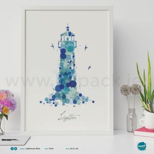 Op de afbeelding: Een ingelijste print met een vuurtorenontwerp gemaakt van blauwe aquarelspatten. Het woord "Lighthouse" staat eronder. De print wordt gepresenteerd op een wit oppervlak met bloemen en andere decoratieve items.