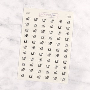 May include: A sheet of stickers featuring small black cat illustrations. The word "CAT" is printed at the top left, and "plannerface" is written in cursive. The stickers are arranged in neat rows and columns.