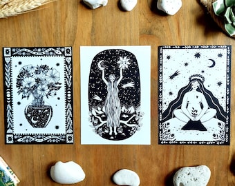 Może przedstawiać: Trzy prostokątne wydruki artystyczne z czarno-białymi ilustracjami. Lewy wydruk przedstawia wazon z kwiatami, środkowy postać trzymającą słońce i księżyc, a prawy siedzącą postać z długimi włosami pod rozgwieżdżonym niebem.