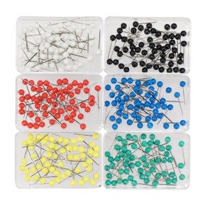 May include: Assortment of colorful push pins in clear plastic containers. The pins are arranged in rows and are available in white, black, red, yellow, and green.