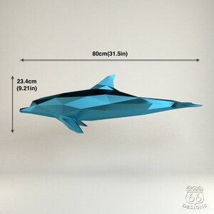 Może przedstawiać: Niebieski origami delfina z czarnym paskiem, o długości 80 cm (31,5 cala) i wysokości 23,4 cm (9,21 cala).
