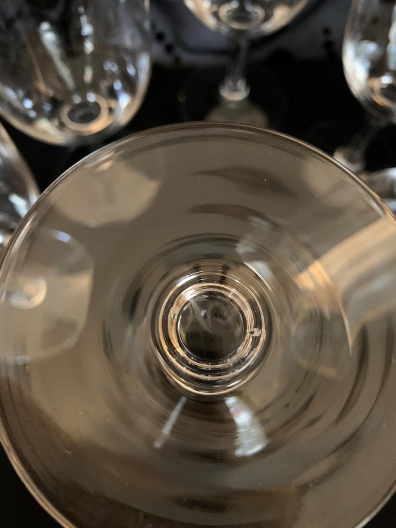 Puede incluir: Una copa de vino de vidrio transparente con una copa ancha y un tallo largo. La copa est&aacute; vac&iacute;a y el tallo es visible.
