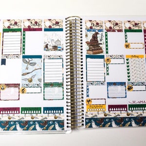 May include: Open planner with a gold spiral binding, featuring a November 2019 layout. The pages are decorated with themed stickers, including images of a sorting hat, books, and owls. The planner includes sections for daily tasks and weekend notes.