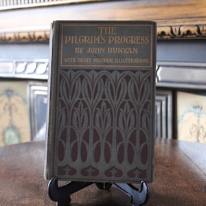 May include: The Pilgrim's Progress by John Bunyan with eight original illustrations. The book cover is green with a burgundy floral pattern.