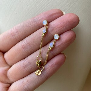 Peut inclure: Boucles d'oreilles en chaîne dorée avec deux gouttes de pierre de lune et deux pierres de lune rondes.