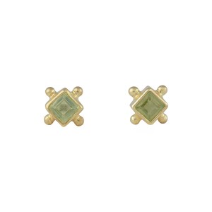 Könnte beinhalten: Ein Paar goldene Ohrringe mit kleinen quadratischen grünen Edelsteinen, die in einem geometrischen Design gefasst sind.