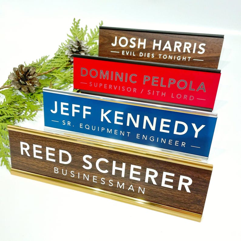 a collection of wooden nameplates with various names on them, including "JOSH HARRIS", "DOMINIC PELPOLA", "JEFF KENNEDY", "REED SCHERER", and "BUSINESSMAN".