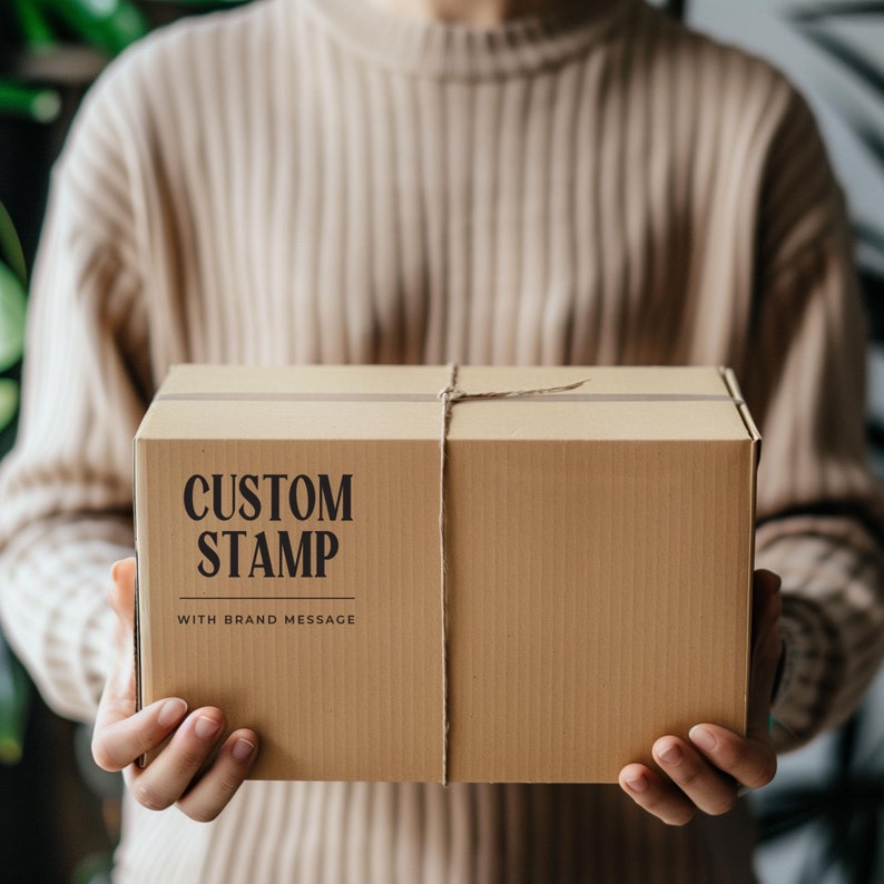 May include: A brown cardboard box with a string tied around it. The box has the text "CUSTOM STAMP WITH BRAND MESSAGE" printed on the front.