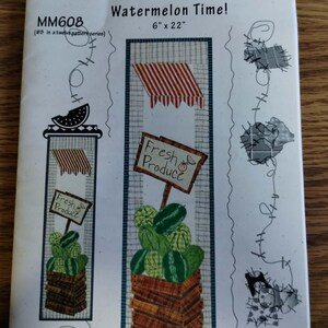 May include: A Patch Abilities, Inc. sewing pattern titled Watermelon Time! MM608, measuring 15.24 cm x 55.88 cm. The white paper cover features illustrations of a watermelon stand with a red and white striped awning, a Fresh Produce sign, and watermelons.