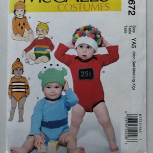 以下が含まれることがあります： McCall's Costumesの型紙封筒M7672（乳幼児用コスチューム）。表紙には、カボチャ、カラフルなストライプの衣装、ガムボールマシン、緑色の生き物、ハチなど、5種類のコスチュームのイラストが描かれています。