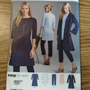 May include: A Simplicity 8557 sewing pattern envelope featuring illustrations of garments including a dark blue tunic, a light blue tunic, dark blue trousers, a light-colored sleeveless top, and a dark blue open-front long-sleeve jacket.