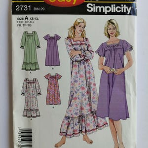 May include: A Simplicity sewing pattern envelope, number 2731, for nightgowns in sizes XS-XL. The cover features illustrations of two individuals wearing different nightgown styles, including long-sleeved and short-sleeved options with floral and solid purple fabric designs.