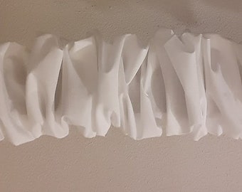May include: White fabric ruched trim with a wavy, pleated design. The trim is made of a soft, lightweight material and is perfect for adding a touch of elegance to any project.