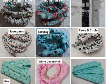 May include: Nine different fabric covers for a vacuum cleaner hose. The covers are in various colors and patterns, including a white cover with black paw prints, a blue cover with white ladybugs, a pink cover with white dots, and a green cover with white bees.