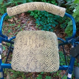 May include: A blue walker with a snake skin patterned seat and armrests. The walker has a padded seat and armrests for comfort.