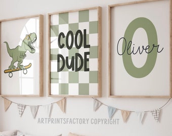 May include: Three framed prints with a green and white checkered pattern, a dinosaur riding a skateboard, and a green letter O with the name Oliver written in black. The prints are hung on a white wall with a string of flags hanging below.