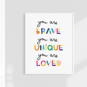 May include: A white framed print with the text "you are BRAVE you are UNIQUE you are LOVED" in colorful block letters.